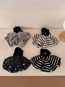 Detail of vintage black and white paisley and striped scrunchies with pearl accents