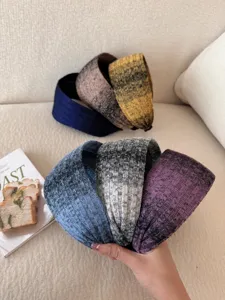 Detailed view of textured knit wide headbands in various retro gradient colors.