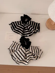 Detailed view of vintage black and white striped hair scrunchies with elegant pearl accents