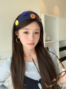 Close-up of knitted headband with puppy embroidery and colorful buttons on model