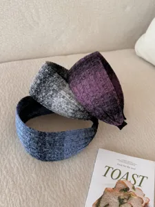 Close-up of three wide knit headbands featuring stylish gradient color patterns