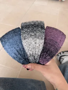 A set of three stylish wide knitted gradient headbands in blue, grey, and purple tones