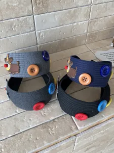 Detail view of wide ribbed knit headbands featuring cute dog embroidery and colorful buttons
