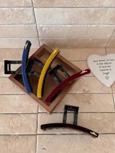 Lot de quatre grandes pinces à cheveux en velours aux couleurs variées avec breloque M dorée.
