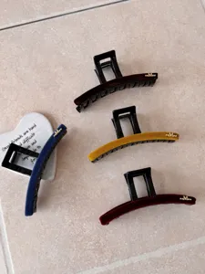 Vue macro montrant la texture en velours des grandes pinces à cheveux en quatre couleurs