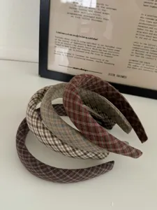 Vue détaillée des serre-têtes rétro à carreaux montrant le tissu texturé en tons terre