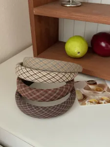 Gros plan de quatre serre-têtes à carreaux vintage avec accessoires d'automne