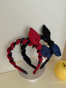 Close-up of two polka dot denim bow headbands displayed on a white plate