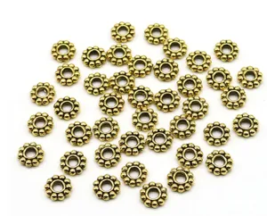 Vue de détail des perles intermédiaires de fleurs dorées, composants de bijoux DIY en alliage.