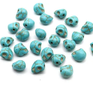 Turquoise skull beads for DIY jewelry making, scattered detail view of gemstone craft findings.
