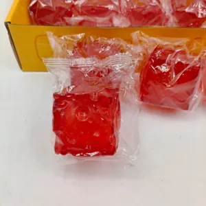 Detailed texture of red translucent square squishy toy in individual clear packaging.