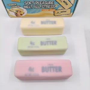 Dettaglio di tre giocattoli squishy a forma di panetto di burro giallo, verde e rosa.
