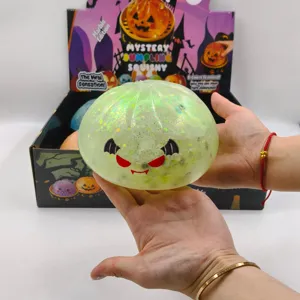 A close-up of a large green glitter Halloween dumpling squishy toy being held in hands