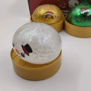 Gros plan détaillé d'un jouet antistress baozi bonhomme de neige pailleté sur base dorée.