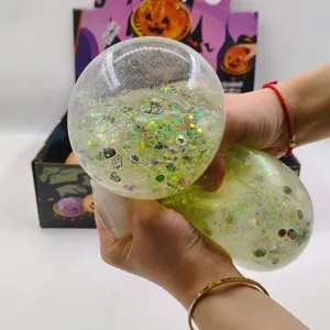 Close-up of hands squeezing a large 15cm Halloween jelly stress toy with green glitter