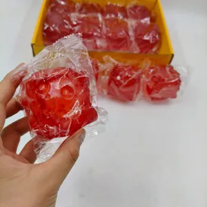 Close-up of a red square squishy toy with textured surface in clear plastic wrap