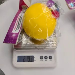 Yellow dog face squishy toy weighing 219.3g on a scale