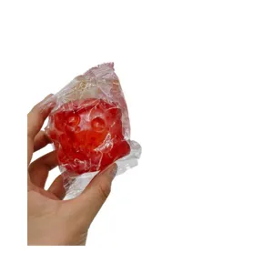 Red textured lunar stress relief squeeze toy ball in clear plastic wrapper for stress relief