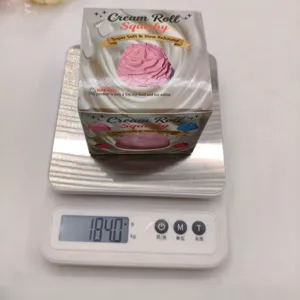 Electronic weight scale showing 184.0g for the packaged cream roll squishy toy
