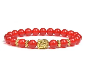 Detailed view of red agate beaded bracelet featuring a golden Buddha head charm and spacer beads.