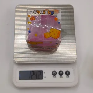 Macro view of a purple cheese-shaped squishy toy on a digital scale showing 124.2 grams