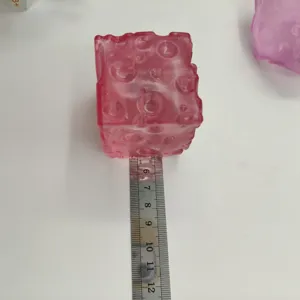 Translucent pink cheese cube squishy toy for stress relief shown with a metal ruler