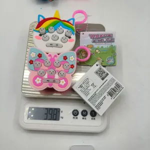 Handheld Whack-a-Mole mini game keychain showing its weight of 39.8 grams on a scale.