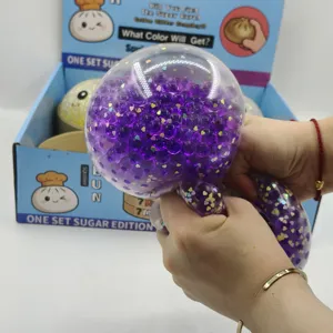 Κοντινό πλάνο μεγάλου παιχνιδιού squishy 15cm με μωβ γκλίτερ που πιέζεται από τα χέρια.