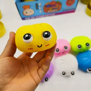 Primer plano de un juguete para apretar con forma de bollo amarillo, ojos grandes y sonrisa