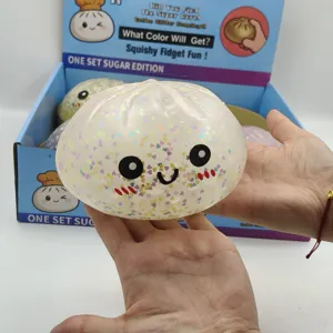 Κοντινό πλάνο παιχνιδιού squishy 15cm σε σχήμα baozi με πολύχρωμα glitter καρδιές.