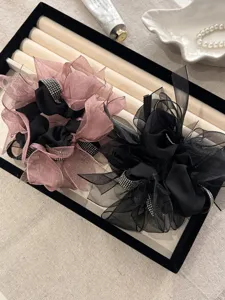 Detailweergave van elegante sprankelende strikscrunchies met strassteentjes op een tray