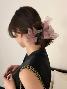Elegante bruine mesh strik haarelastiek met strassteentjes op een lage knot
