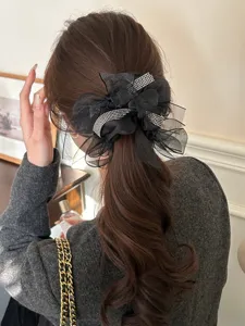Detailoverzicht van een elegante zwarte tule strik scrunchie met glimmende strass