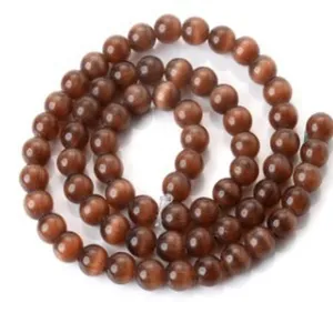 Close-up detail of brown cat eye loose beads, drilled round beads for DIY bracelet parts.