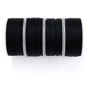Close-up detail view of black nylon cord spools for DIY crafts, with neat winding texture.