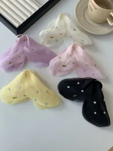 Detailed view of assorted tulle bow hair clips with crystal accents and Love charms.