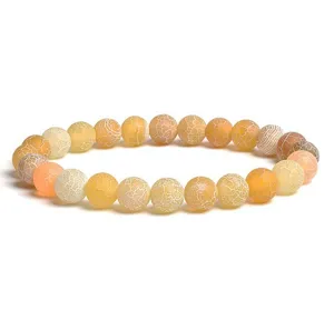 Close up of frosted weathered agate beaded bracelet showing crackled texture and warm tones.