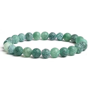 Green cracked agate beaded bracelet detail, natural gemstone stretch jewelry close-up.