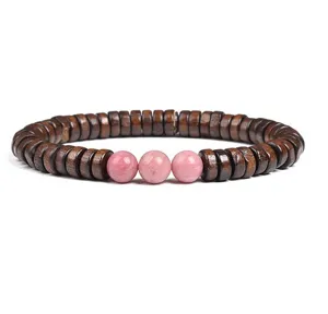 Close-up detail view of dark brown wooden disc beads bracelet featuring three pink round stones.