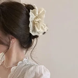 Gros plan d'une pince à cheveux nœud en dentelle crème élégamment coiffée sur un modèle