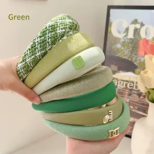 Detailed view of multiple green headbands featuring various textures and stylish accents