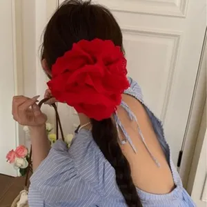 Large red lace flower hair scrunchie for elegant ponytail styling shown on a model
