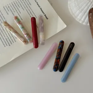 Λεπτομερής όψη από διάφορα πολύχρωμα κλιπ μαλλιών από οξική κυτταρίνη σε λευκό φόντο