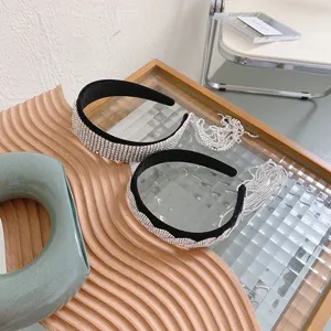 Detailaufnahme von silbernen Strass-Stirnbändern mit hängenden Fransen und Quasten