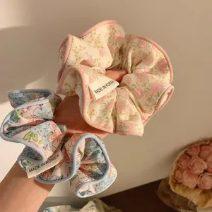 Gros plan de chouchous à fleurs avec bords festonnés et étiquettes Made in Korea.