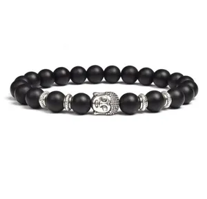 Close-up detail of black bead bracelet featuring silver Buddha head charm and metal spacers.
