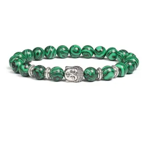 Close-up of green stone beaded bracelet with silver Buddha head charm and metal spacer beads.