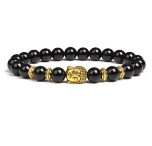 Closeup detail of 8mm black stone bead bracelet featuring a golden Buddha head and spacers.