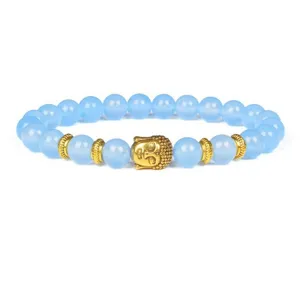 Blue gemstone bead bracelet with a central golden Buddha head charm and decorative spacers.