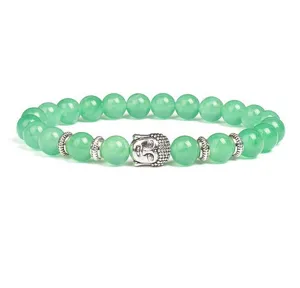 Detailed close-up of green stone bead bracelet featuring a carved buddha head and silver spacers.